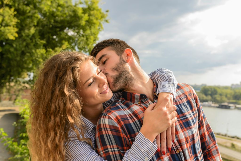 Couple embracing outdoors, reflecting the reconnection and trust rebuilt through couples therapy after infidelity.