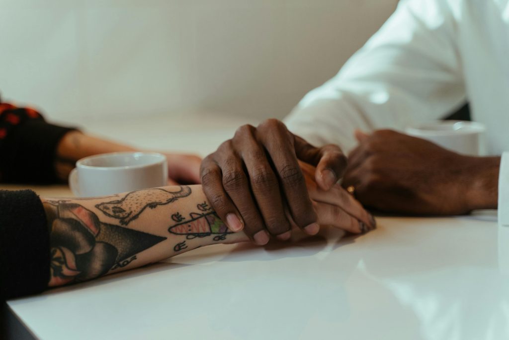 Close-up of a couple holding hands during a therapy session, illustrating support in overcoming ptsd triggers through joint therapy efforts.