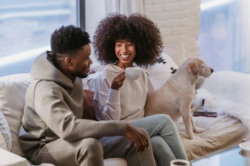 Joyful couple with their dog, enjoying a moment of laughter, showcasing the healing power of couples therapy after infidelity.