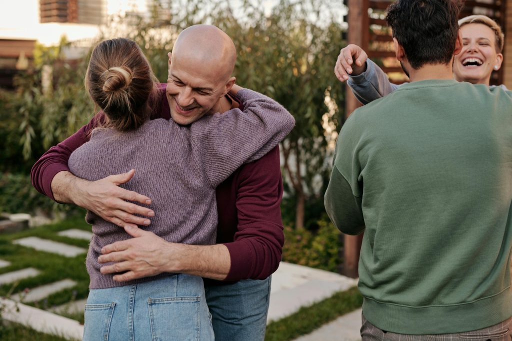 Group of friends sharing a joyful embrace outdoors, depicting the support and happiness essential in treating depression and anxiety.