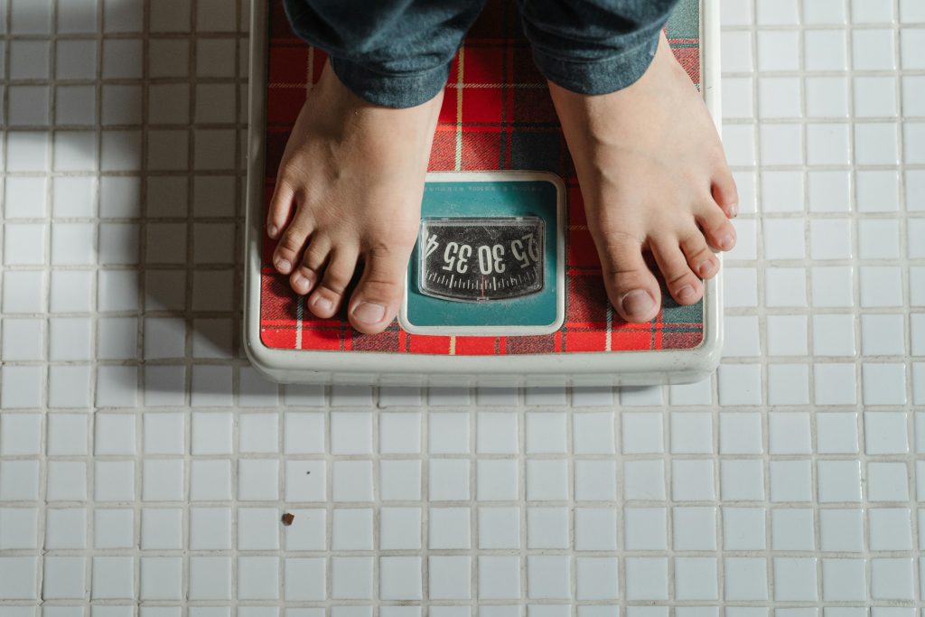 Close-up of a person standing on a scale, symbolizing the challenges of managing depression and anxiety related to body image.