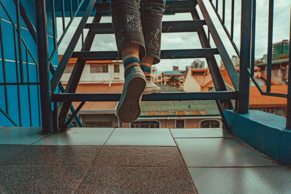Person ascending stairs in the city, symbolizing steps in coping with trauma and self-healing from past experiences.