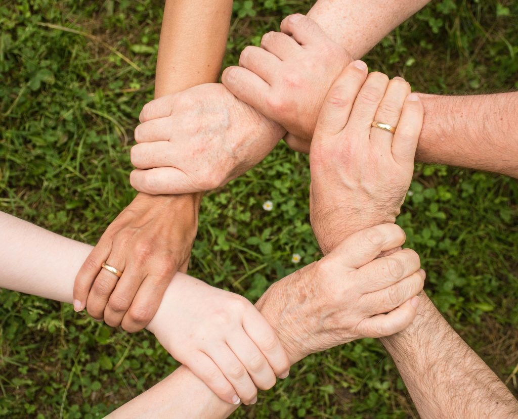 Diverse hands gripping one another in unity, representing support for invisible disabilities.