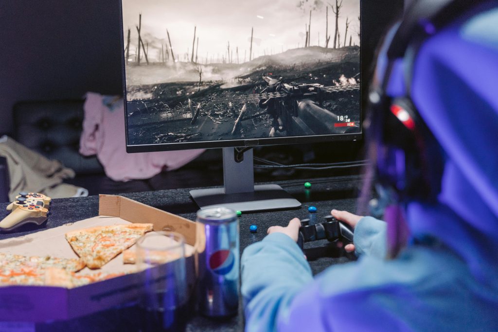 Gaming addiction awareness depicted by a person playing a video game with snacks nearby.