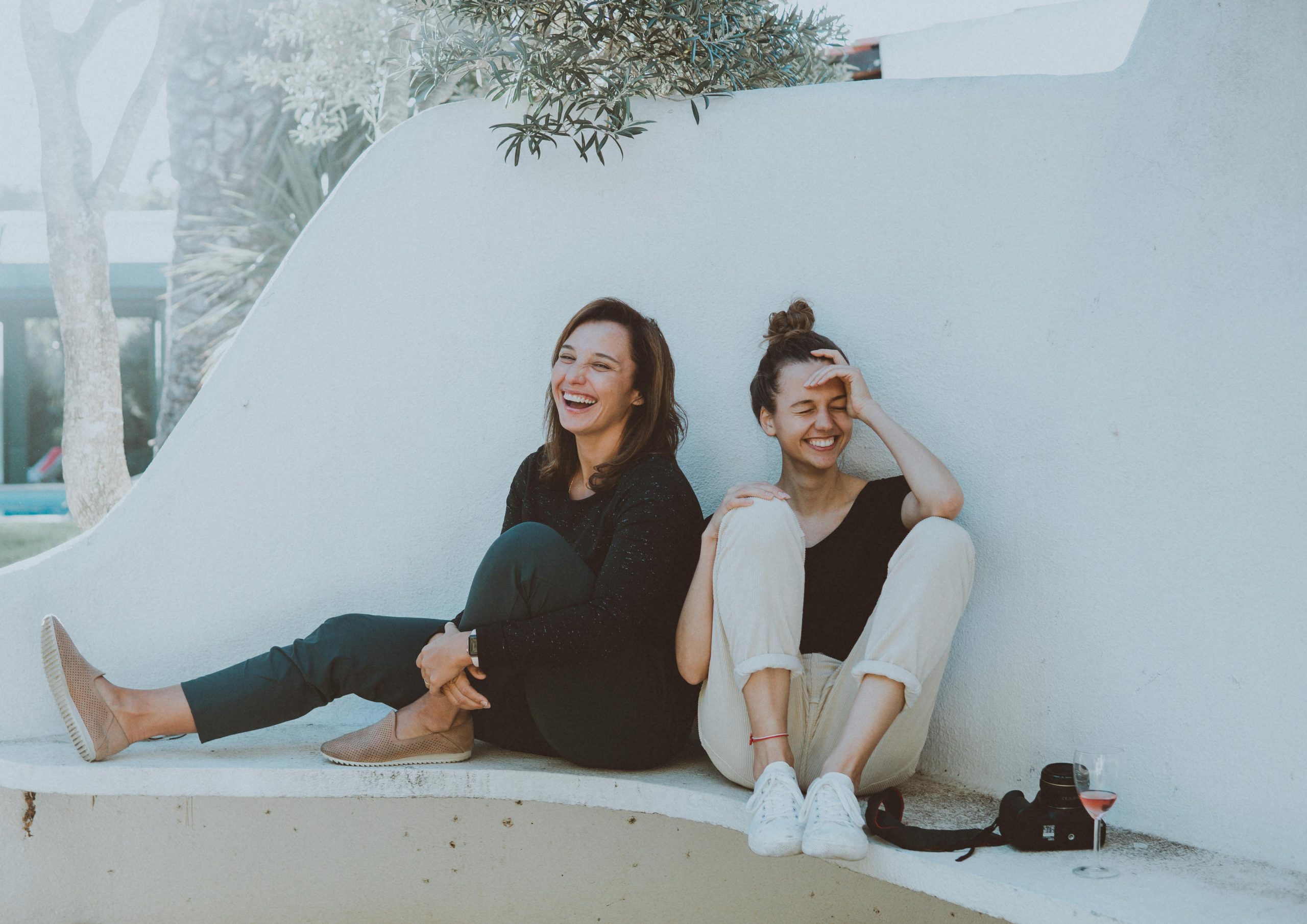 Mother-Daughter-Laughing-Together A mother and daughter laughing together while sitting outdoors, highlighting the warmth and joy of shared moments.