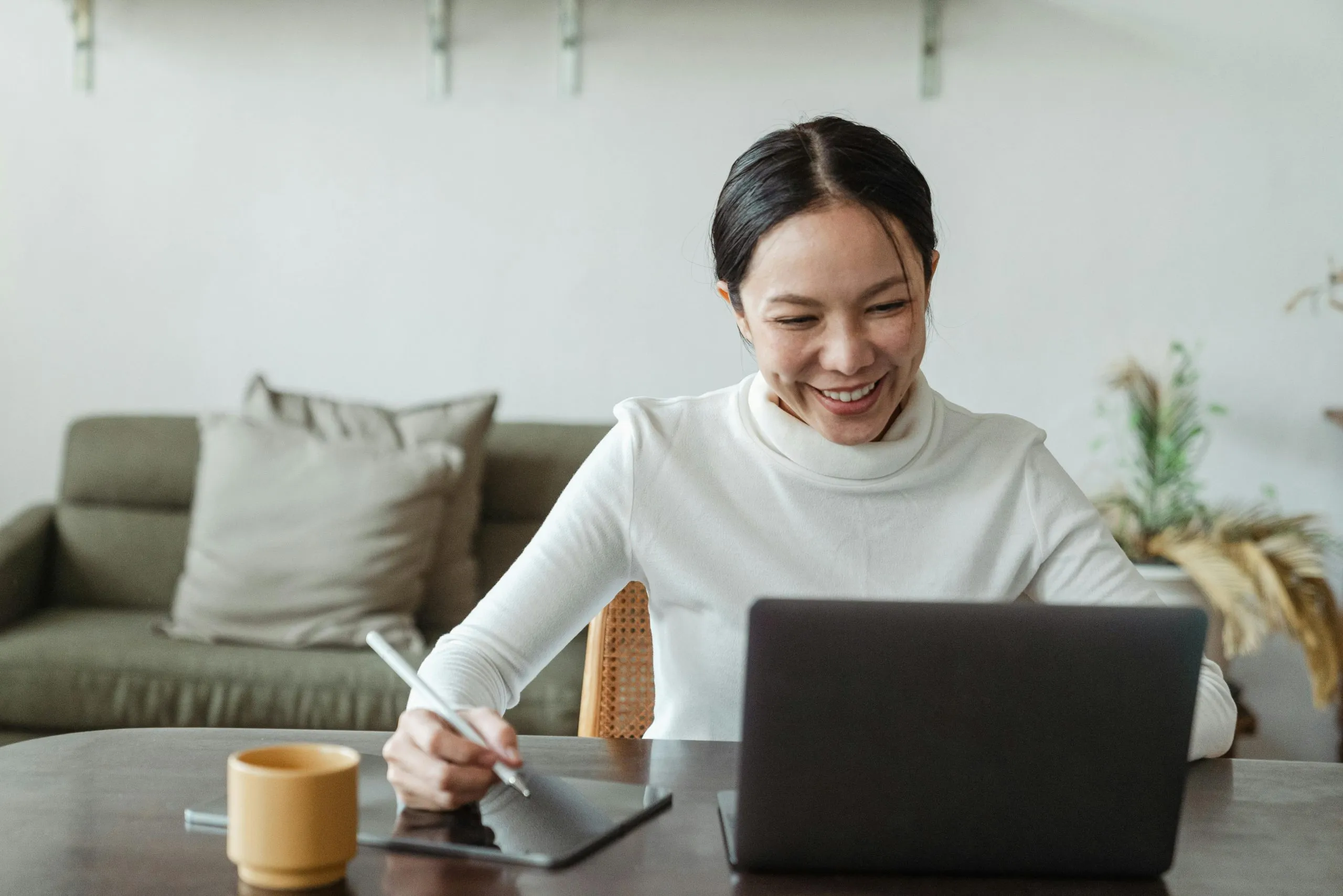 Smiling asian woman attending an online therapy session, representing accessible adhd support and executive functioning help through virtual therapy.