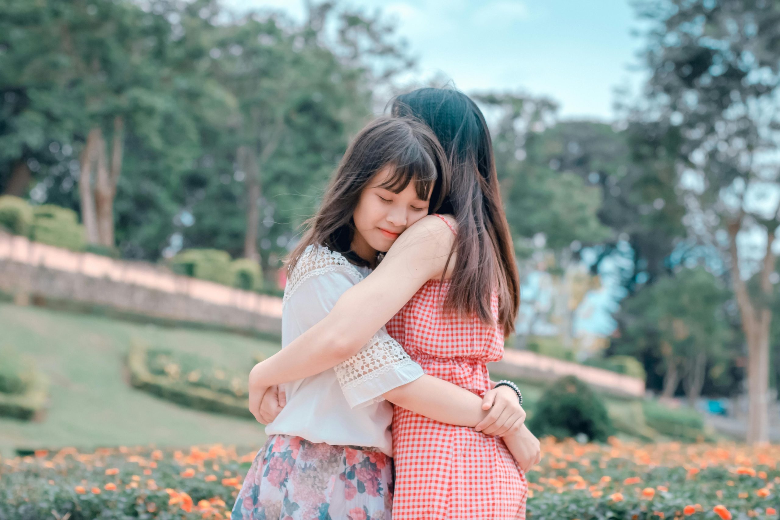 Teen-Supportive-Friendship-Hug Teenage girl and her mom hugging each other outdoors in a park