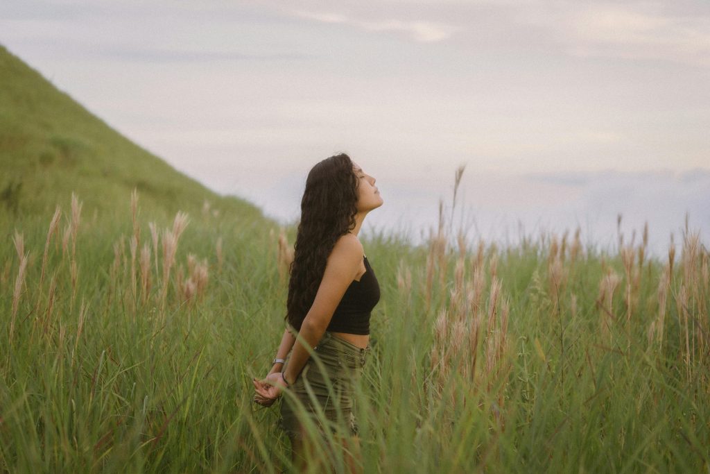 Woman in a field practicing mindfulness to lower cortisol