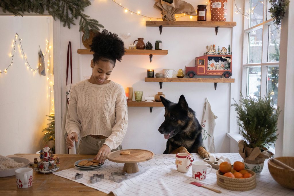 Woman baking with dog in christmas kitchen — overwhelming expectations christmas.