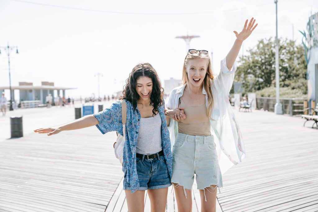 Two happy friends enjoying a sunny day together, representing prevention and early mental health support.