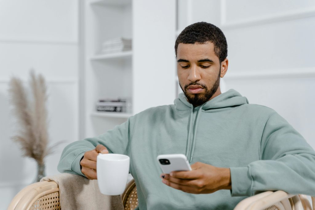 Man looking concerned while checking health information on his phone at home