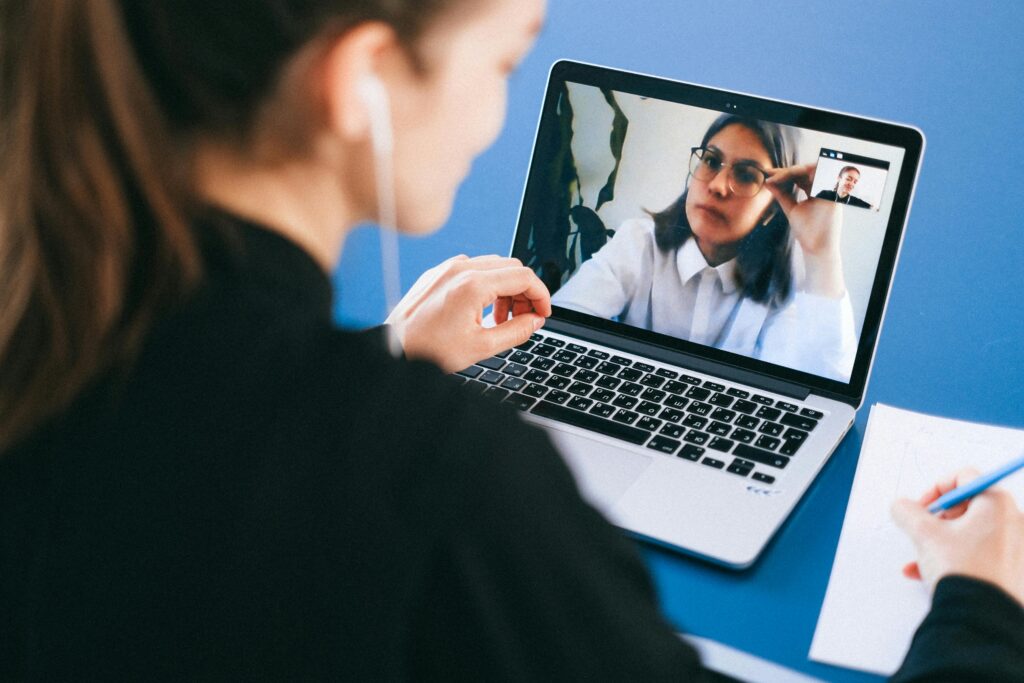 Person taking notes during video call with therapist, showing how to manage adhd with support