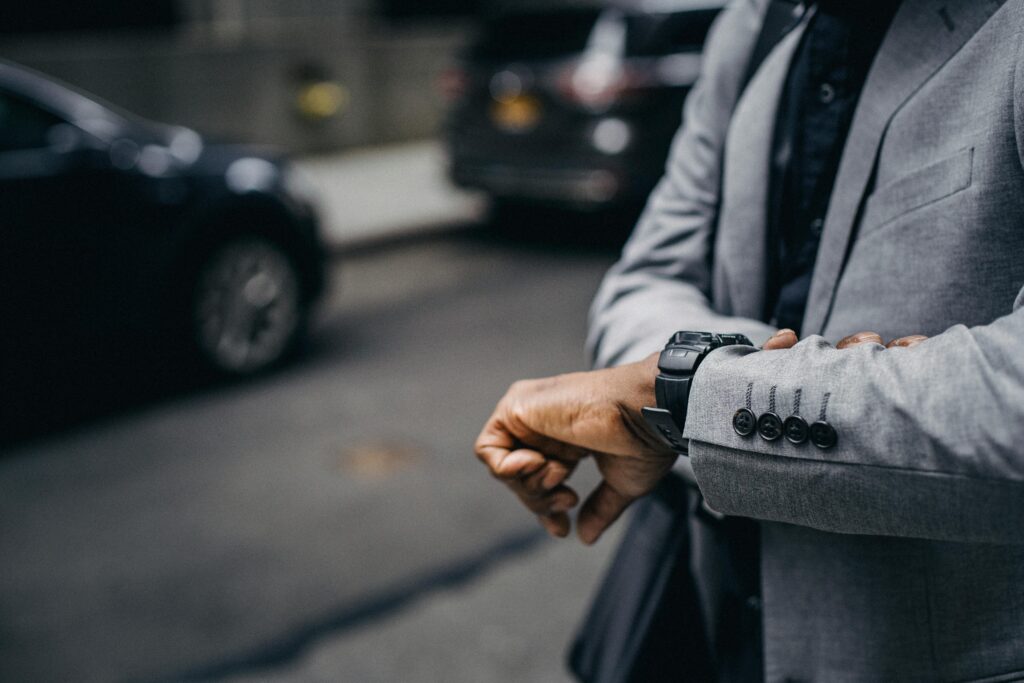Man checking the time while struggling with why do i cancel plans at the last minute feelings