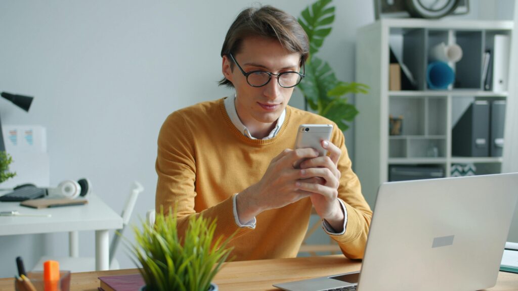 Young man looking emotional while using his phone and searching why do i cry a lot online