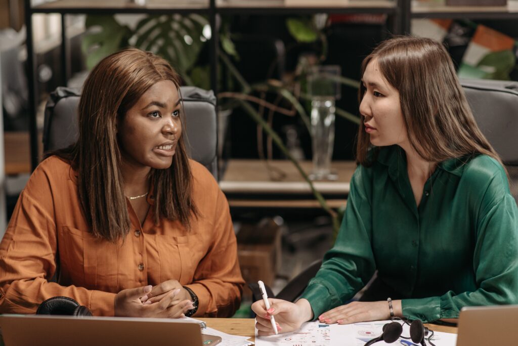 Two professional women engaged in a thoughtful conversation, illustrating therapy for high-achieving woman seeking support and growth