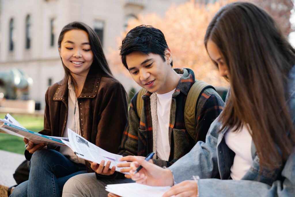 Students reviewing notes together outdoors while practising time management for students and academic success